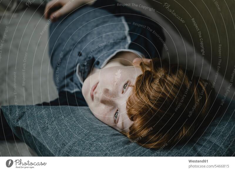 Portrait of daydreaming boy lying on couch looking at distance human human being human beings humans person persons caucasian appearance caucasian ethnicity