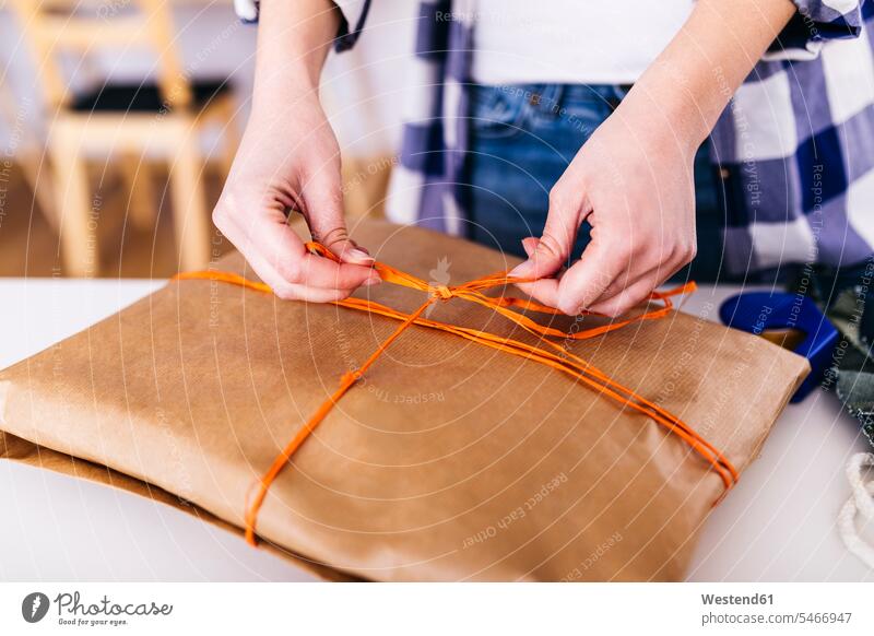 Close-up of woman wrapping a package parcel packet packets parcels females women Adults grown-ups grownups adult people persons human being humans human beings