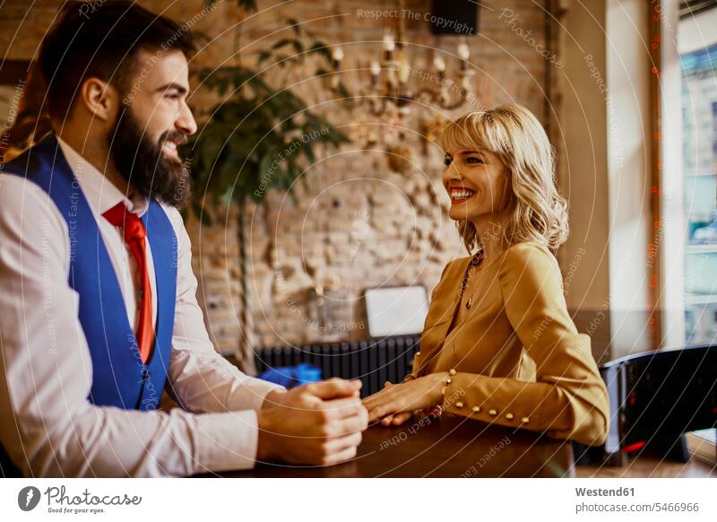 Elegant couple smiling at each other in a bar elegant chic elegance stylishly classy twosomes partnership couples bars smile style people persons human being