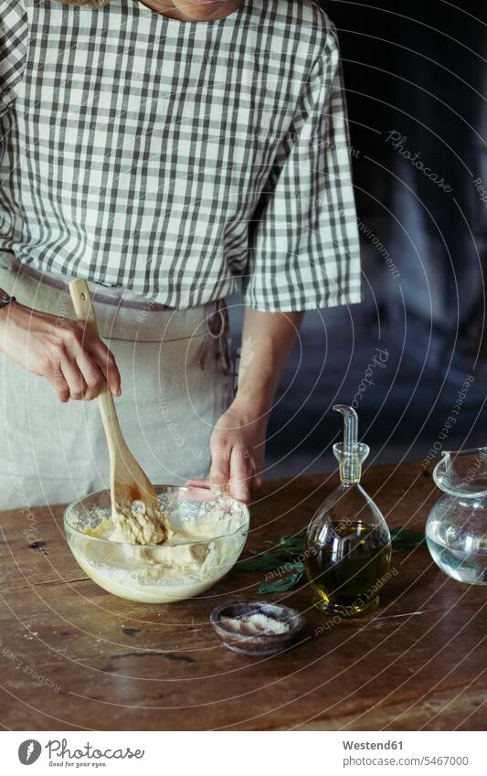 Young woman in kitchen preparing dough for fresh chickpea cake Chickpea Chick Peas Cicer arietinum Chickpeas Flour Flours stirring Food Preparation