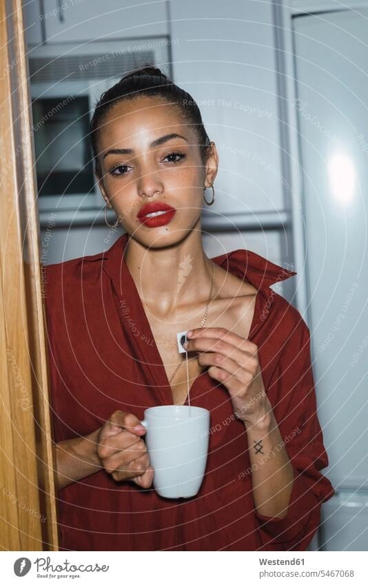 Portrait of beautiful young woman with cup of tea at home Tea Cup Tea Cups Teacup Teacups females women portrait portraits Teas Adults grown-ups grownups adult