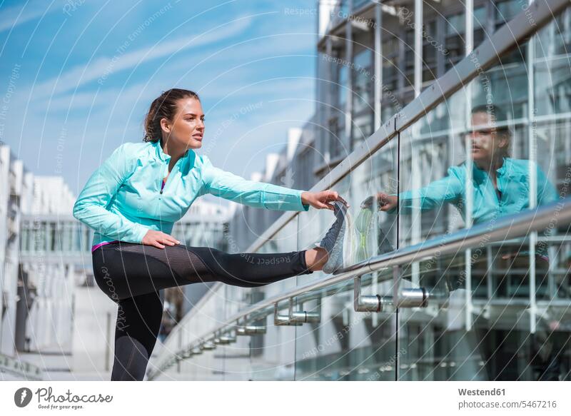 Young woman doing stretching exercise in the city females women exercises town cities towns Adults grown-ups grownups adult people persons human being humans