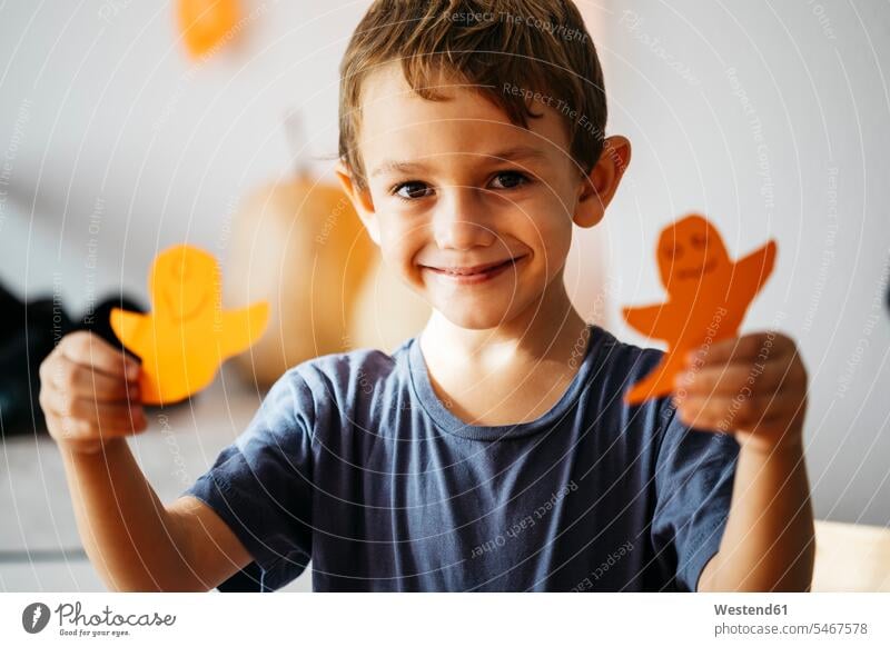 Portrait of smiling little boy with two cardboard ghosts Card Board Ghost Ghosts Specters Spirits boys males portrait portraits smile child children kid kids