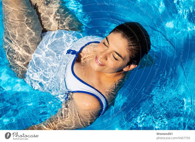 Woman With A Hat Relaxing In A Swimming Pool by Stocksy