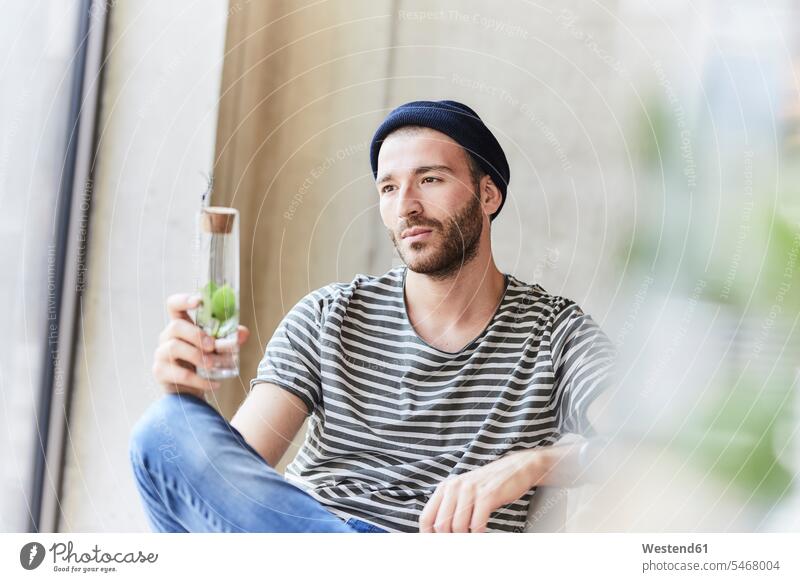 Thoughtful young man holding plant in a jar pensive thoughtful Reflective contemplative Plant Plants jars caucasian caucasian ethnicity caucasian appearance