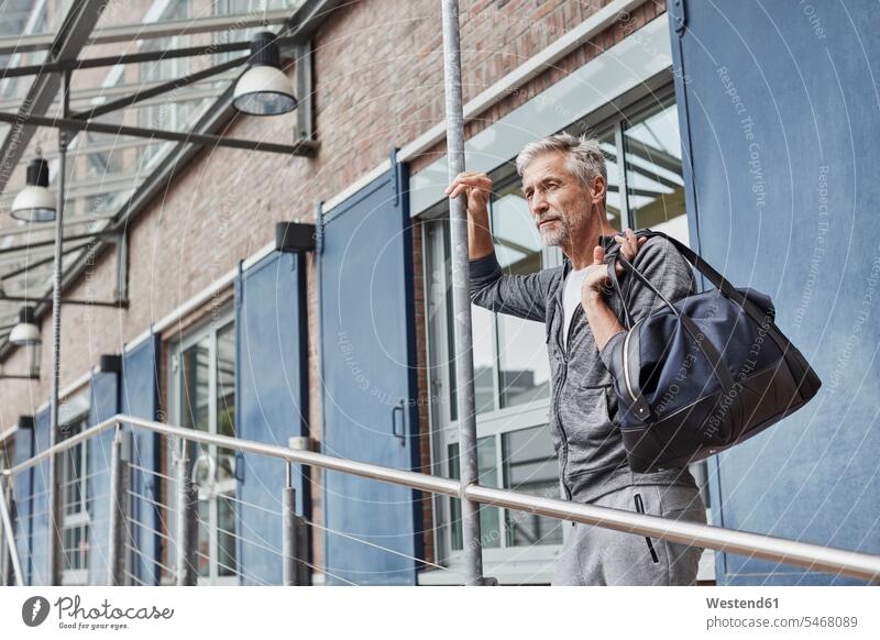 Mature man with sports bag standing in front of gym men males gyms Health Club Gym Bag Adults grown-ups grownups adult people persons human being humans