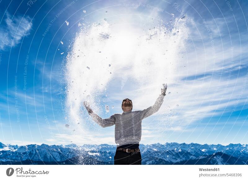 Germany, Bavaria, Brauneck, man in winter playing with snow in the mountains men males hibernal Adults grown-ups grownups adult people persons human being