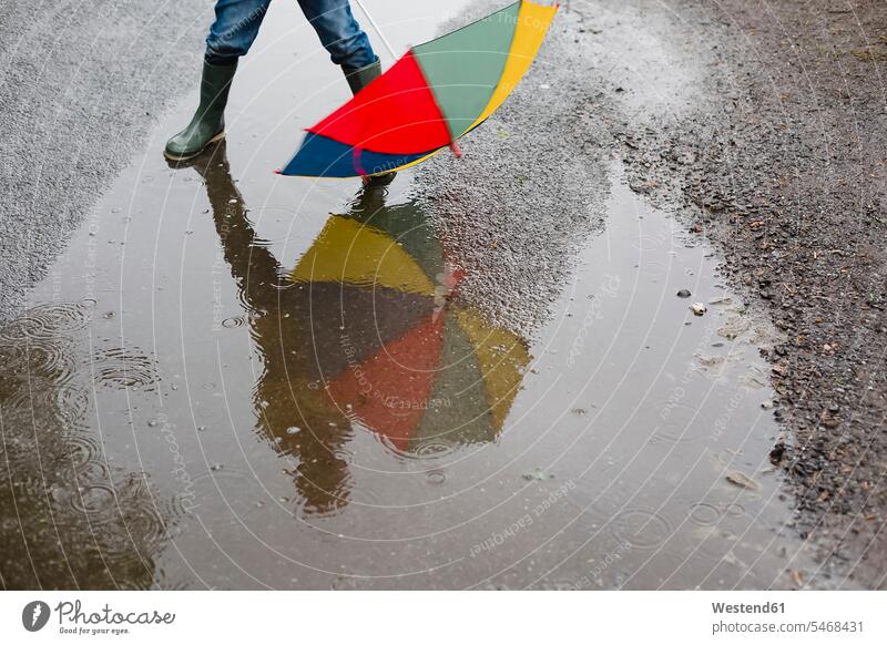 Little boy with umbrella and rubber boots standing in a puddle, partial view Wellington Boot Gumboots Rubber Boot wellies Wellington Boots wellingtons puddles