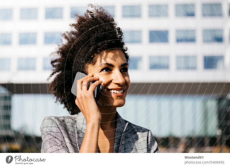 Portrait of smiling businesswoman on cell phone outside office building on the phone call telephoning On The Telephone calling businesswomen business woman