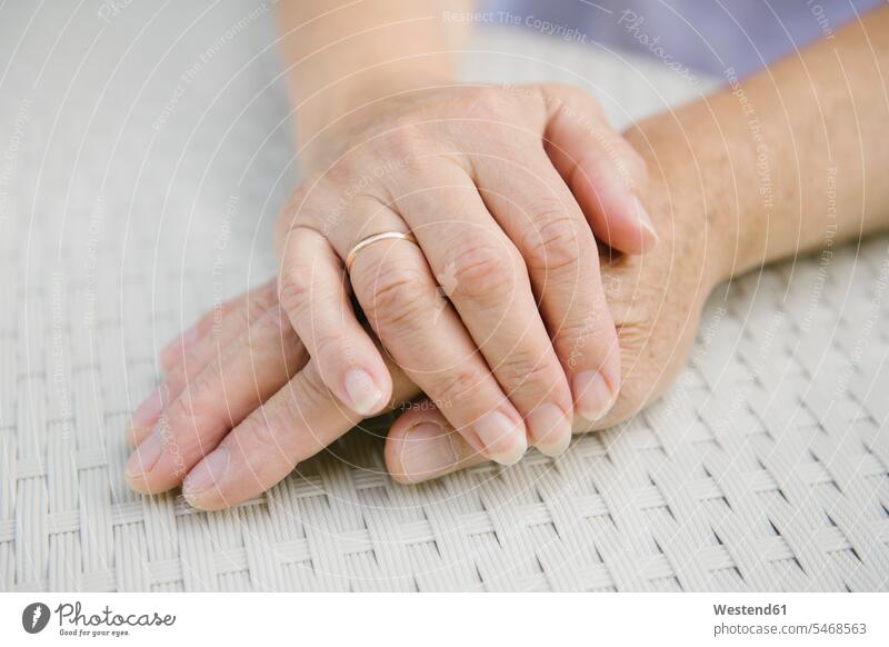 Senior couple sitting at garden table holding hands, close-up human human being human beings humans person persons caucasian appearance caucasian ethnicity