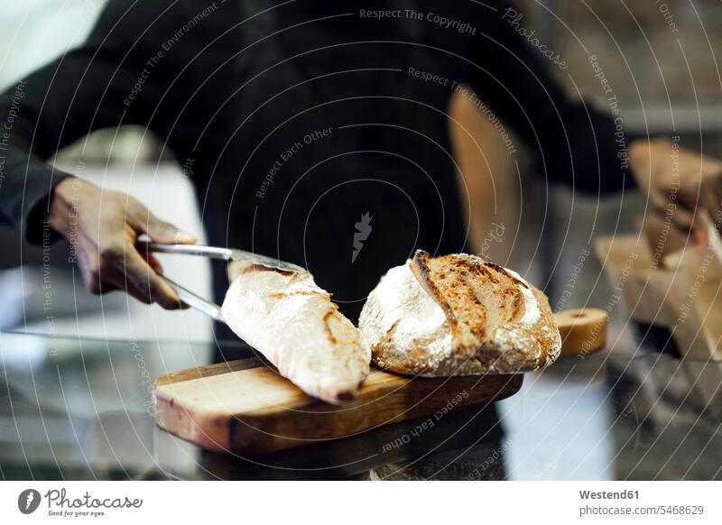 Salesman packing fresh bread while working at bakery color image colour image outdoors location shots outdoor shot outdoor shots day daylight shot