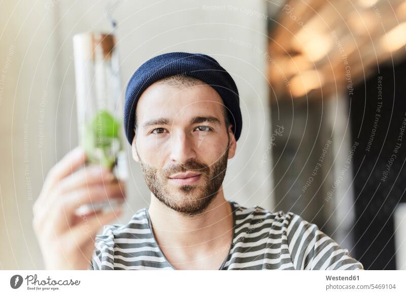 Portrait of young man holding plant in a jar Germany shielding shielded screen screened sustainability sustainable nature protection nature conservation