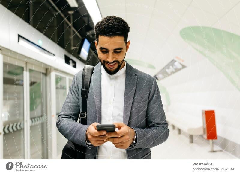 Young businessman using cell phone in subway station business life business world business person businesspeople Business man Business men Businessmen bags