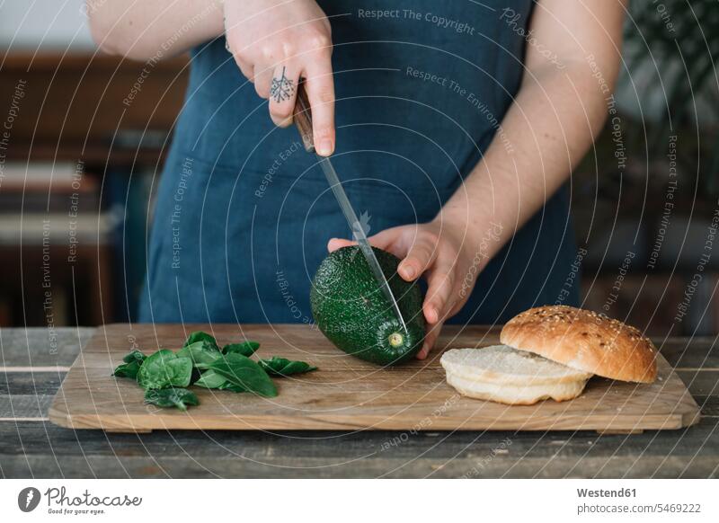 Woman preparing vegan burger, slicing avocado baking bake cooking vegetarian Vegetarian Food food and drink Nutrition Alimentation Food and Drinks caucasian