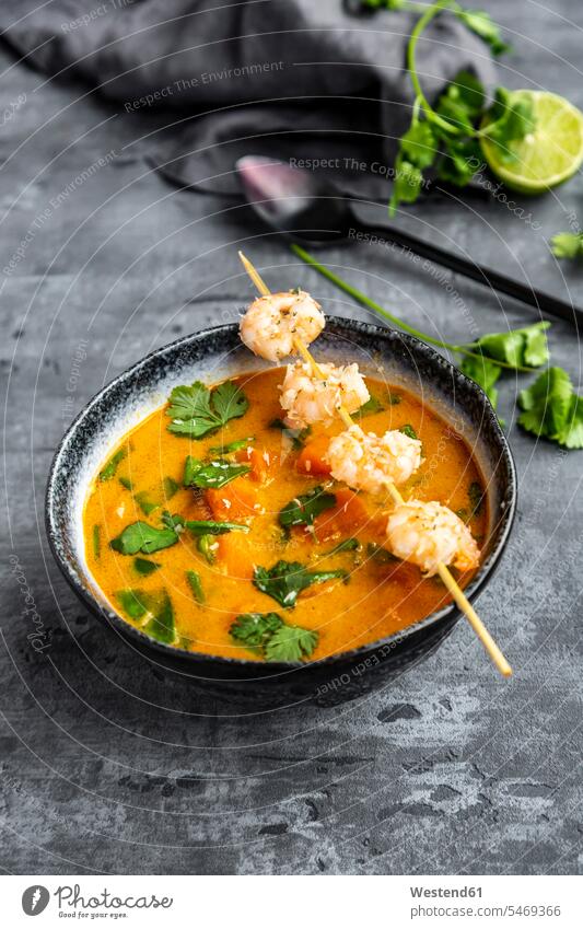 Bowl of sweet potato soup with shrimps, coconut flakes and fresh coriander Bowls garnished sliced ready to eat ready-to-eat mashed puréed spring onion