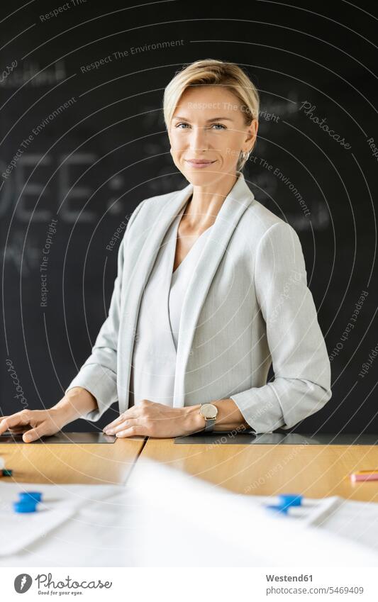 Portrait of confident blond businesswoman in conference room with blackboard Occupation Work job jobs profession professional occupation business life