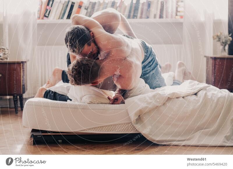 Gay couple fighting in bed gay gay men gay man homosexual men homosexual man embracing embrace Embracement hug hugging beds twosomes partnership couples queer