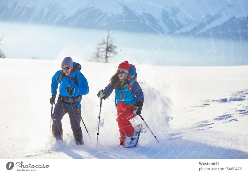 Austria, Tyrol, snowshoe hikers running through snow winter hibernal snowshoeing couple twosomes partnership couples winter sport Winter Sports wintersports