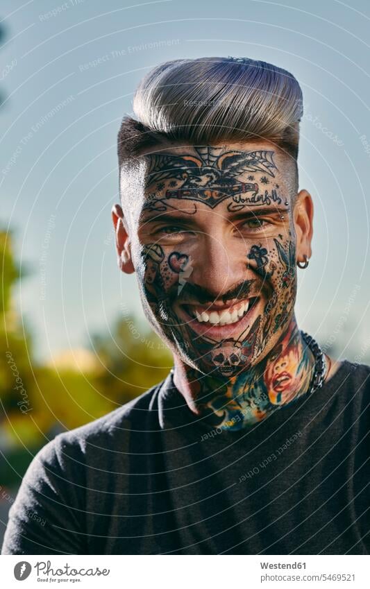Portrait of smiling tattooed young man outdoors portrait portraits men males smile tattoos Adults grown-ups grownups adult people persons human being humans