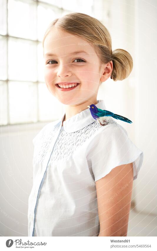 Portrait of happy little girl with toy bird on shoulder portrait portraits happiness birds females girls toys people persons human being humans human beings