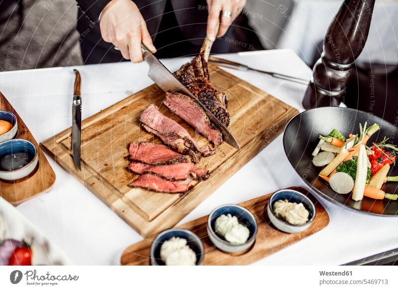 Hands of chef slicing tomahawk steak indoors indoor shot indoor shots interior interior view Interiors elevated view High Angle View High Angle Shot Part Of