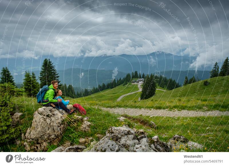 Germany, Lenggries, young hiker couple having a rest break wanderers hikers twosomes partnership couples resting hiking people persons human being humans