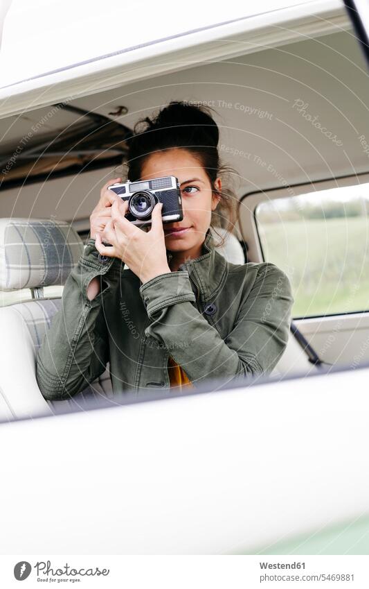 Young woman sitting in camper, taking pictures transport motor vehicles road vehicle road vehicles Auto automobile Automobiles cars motorcar motorcars