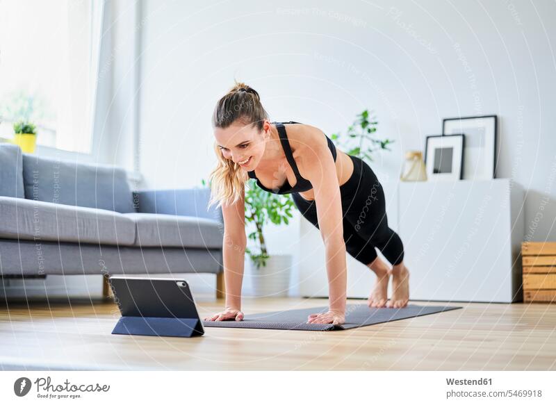 Woman learning exercise on internet through digital tablet at home color image colour image indoors indoor shot indoor shots interior interior view Interiors