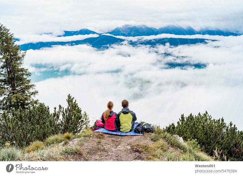 Young couple on a hiking trip in the mountains having a break, Herzogstand, Bavaria, Germany touristic tourists Blankets back-pack back-packs backpacks rucksack