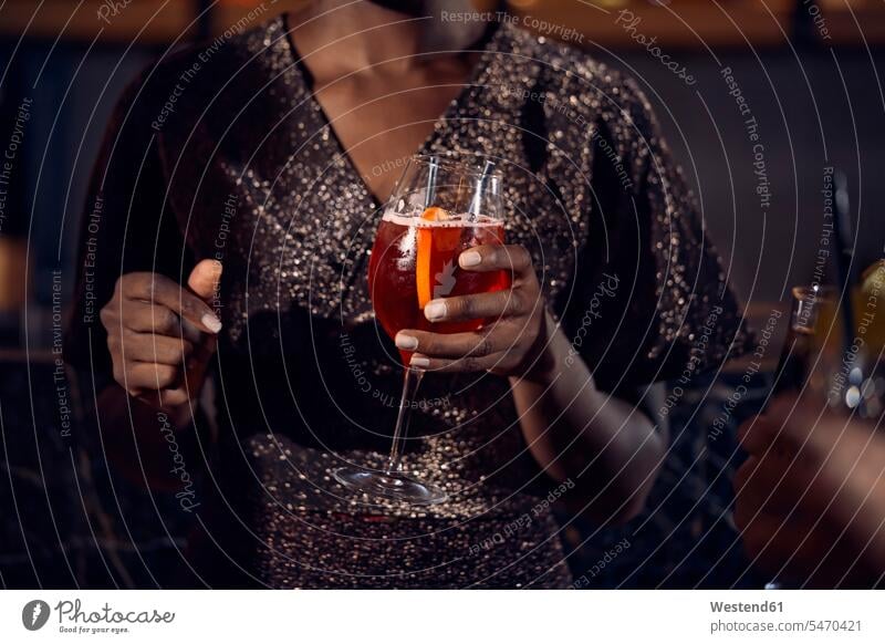 Close-up of woman holding a cocktail glass in a bar human human being human beings humans person persons African black black ethnicity coloured 1
