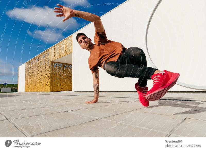 Free Photo  Young man break dancing on wall