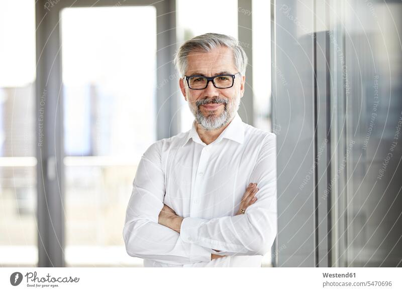 Portrait of smiling businessman standing at the window portrait portraits confidence confident Businessman Business man Businessmen Business men smile windows