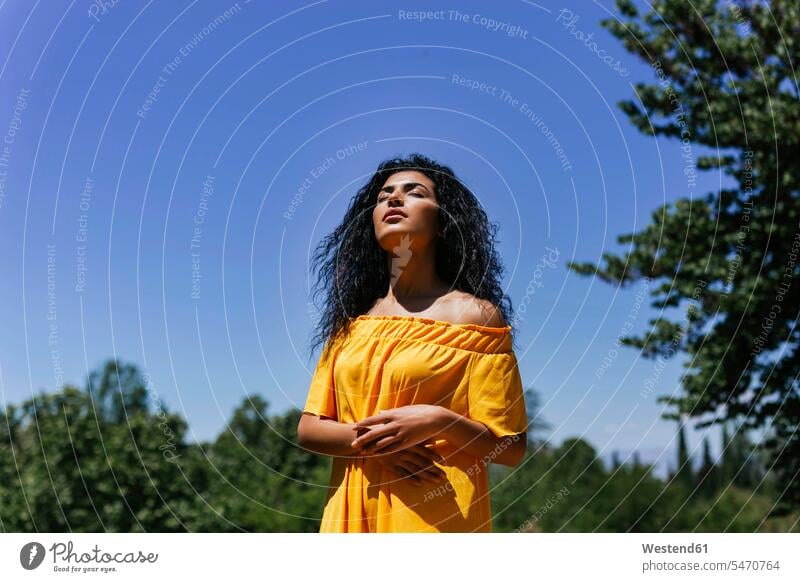 Portrait of young black-haired woman enjoying sunshine human human being human beings humans person persons Middle Eastern Middle-eastern Ethnicity 1