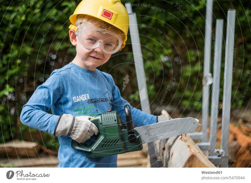 Portrait of boy with toy saw pretending to saw wood portrait portraits sawing saws toys wooden boys males tool tools Tool Kit device devices child children kid