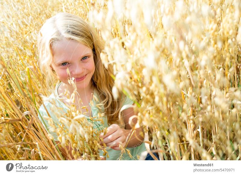 Smiling girl standing in ripe wheat field learn ripeness explore exploring grow growing Getaway Tour Tours Trip Trips location shot location shots outdoor