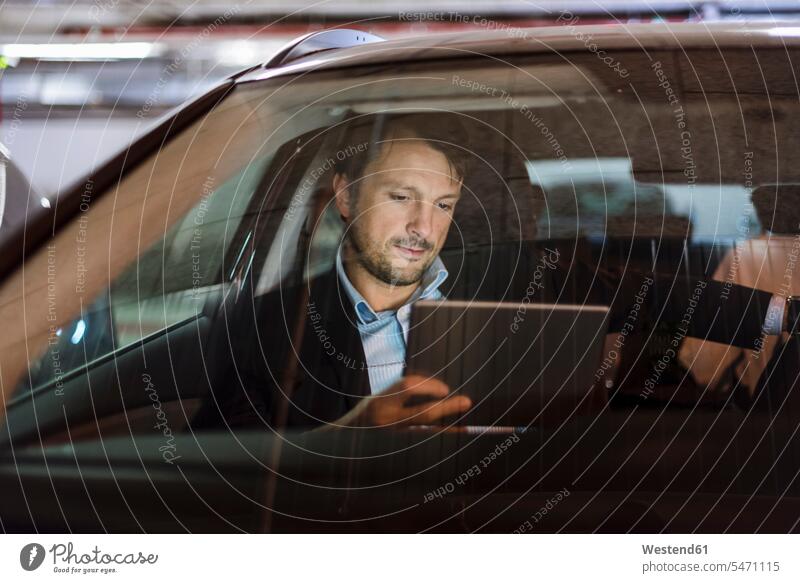 Businessman sitting in car at night, using digital tablet digitizer Tablet Computer Tablet PC Tablet Computers iPad Digital Tablet digital tablets Business man