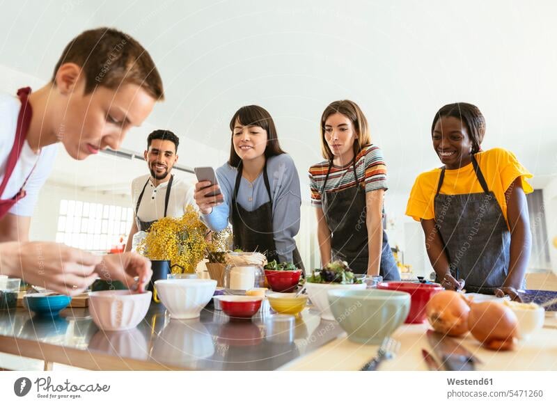 Friends in a cooking workshop watching instructor kitchen friends mate female cook cooking class training course Exercise Class Training Class friendship chef