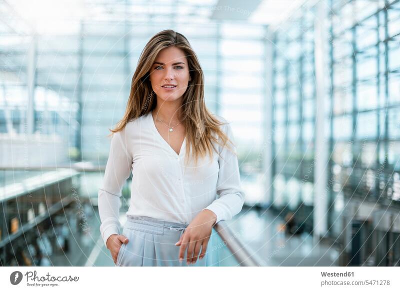 Portrait of smiling young woman standing at railing smile females women portrait portraits Railing Railings Adults grown-ups grownups adult people persons