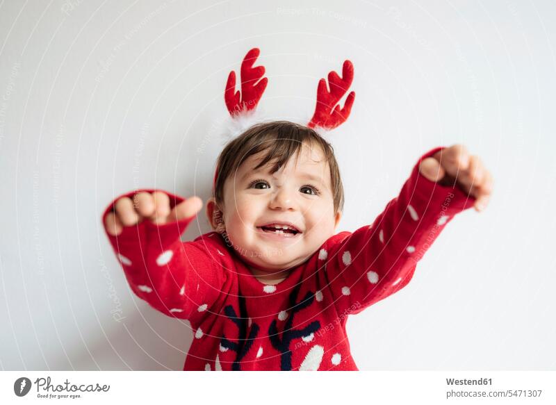 Portrait of happy baby girl with reindeer antlers headband at Christmas time portrait portraits hair-band ribbon hair ribbon Antler Antlers caribu caribou