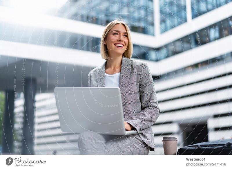 Smiling young businesswoman using laptop in the city Occupation Work job jobs profession professional occupation business life business world business person