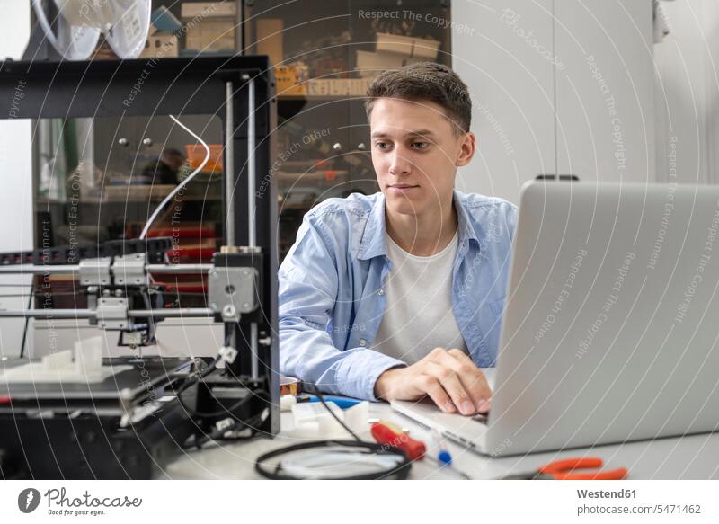 Student setting up 3D printer, using laptop human human being human beings humans person persons caucasian appearance caucasian ethnicity european 1