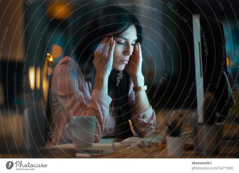 Young woman sitting at desk in office having headache Occupation Work job jobs profession professional occupation business life business world business person