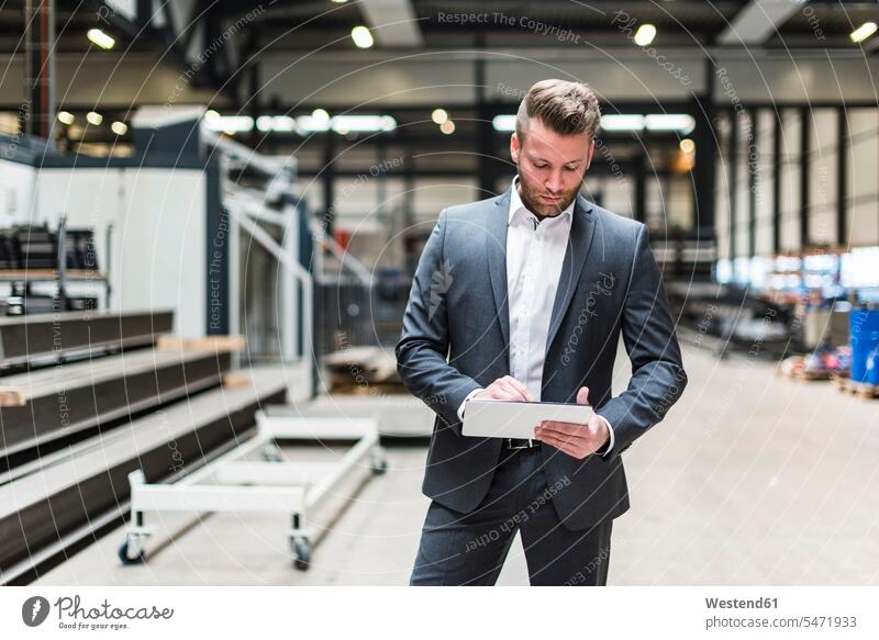 Businessman with tablet standing on factory shop floor Business man Businessmen Business men digitizer Tablet Computer Tablet PC Tablet Computers iPad