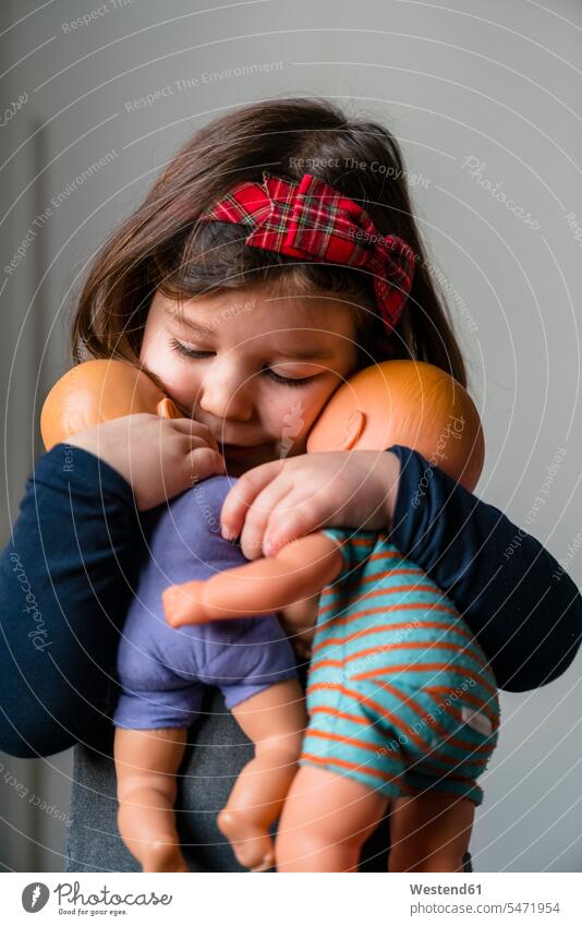 Close-up of cute girl embracing her dolls at home color image colour image 2-3 years 2 to 3 years toddlers Toddler toddler age infant infants children kid kids