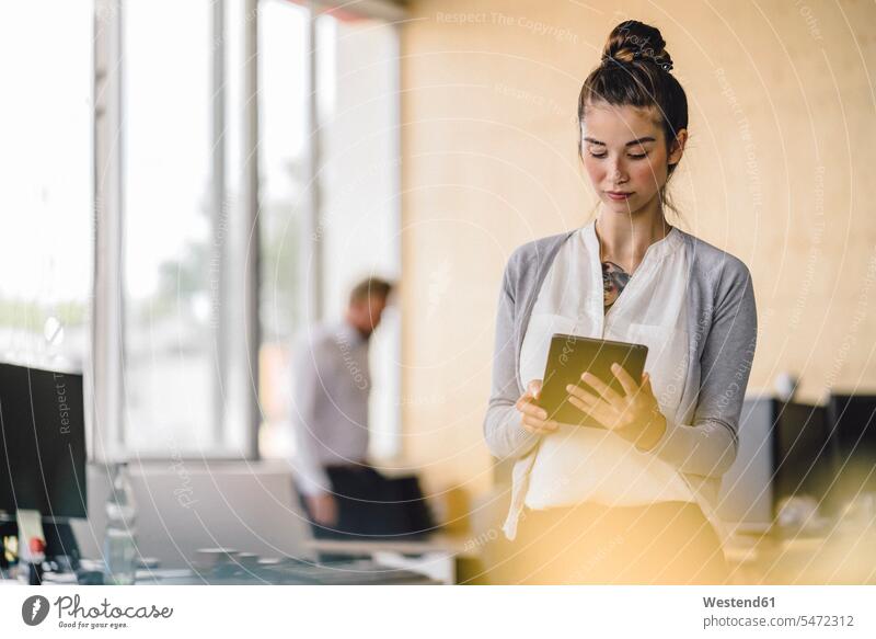 Young woman working in office, using tablet colleagues digitizer Tablet Computer Tablet PC Tablet Computers iPad Digital Tablet digital tablets business people