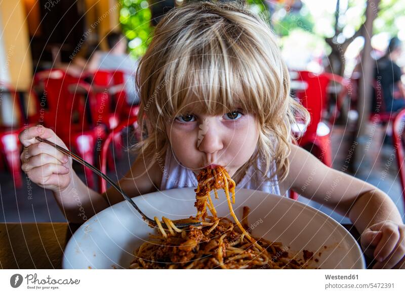 Girl eating spaghetti at restaurant outdoors location shots outdoor shot outdoor shots day daylight shot daylight shots day shots daytime portrait portraits