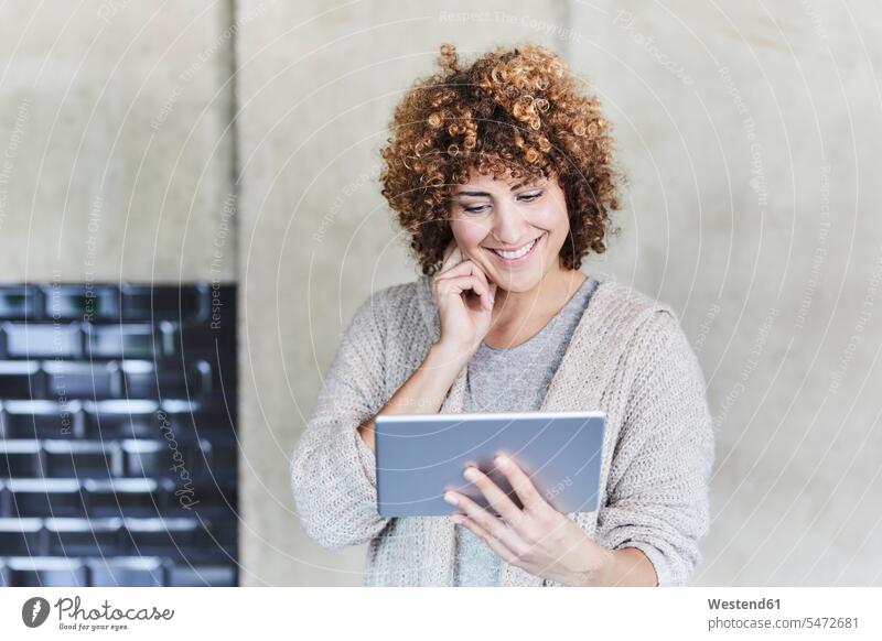 Smiling woman using tablet at concrete wall digitizer Tablet Computer Tablet PC Tablet Computers iPad Digital Tablet digital tablets females women smiling smile