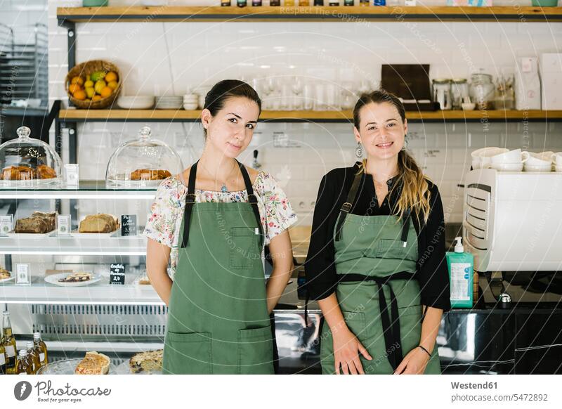 Smiling women standing by counter at coffee shop color image colour image indoors indoor shot indoor shots interior interior view Interiors day daylight shot