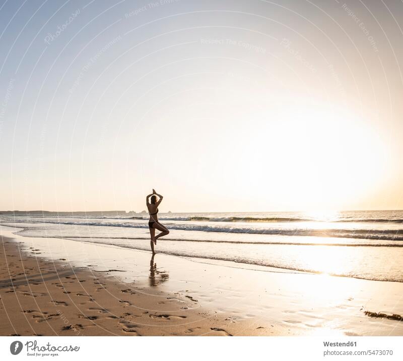 Yoga Pose At The Beach During Sunset Stock Photo, Royalty-Free