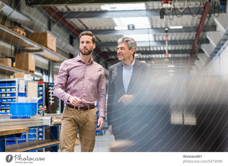 Businessmen during meeting in production hall man males discussion discussing factory factories Adults grown-ups grownups adult people persons human being